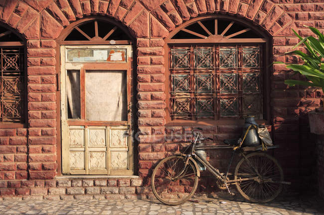 Bicicleta frente a la casa, Fatehpur Sikri, la Ciudad de la Victoria, Construida durante la segunda mitad del siglo XVI, Arquitectura mogol, hecha de piedra arenisca roja, capital del Imperio mogol, Patrimonio de la Humanidad por la UNESCO, Agra, Uttar Pradesh, India - foto de stock