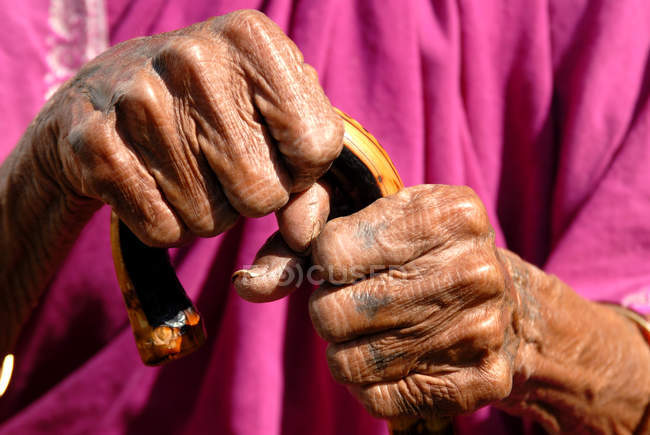 Abgeschnittenes Bild einer alten indischen Landfrau, die Stock mit zwei Händen hält. lonavala, maharashtra, indien. — Stockfoto