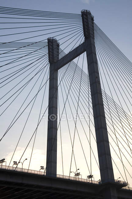 Низький кут огляду конструкції моста з дротами проти неба — стокове фото