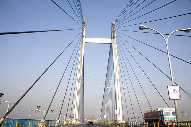 View of modern bridge with wires and posts, truck moving on road — Stock Photo