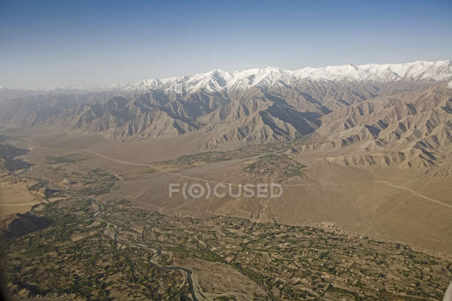 Aerial view of the snow covered Himalaya mountains with the Indus river and the villages with their fields in the valley near Leh as seen on the flight from Delhi to Leh-Ladakh.India — Stock Photo