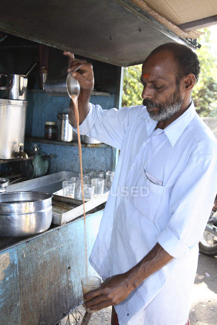 Hombre barista indio con marca tilak en la tienda de té en el trabajo, India - foto de stock