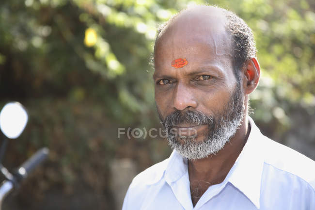 Anziano indiano con baffi, barba e tilak segno sorridente e guardando la fotocamera — Foto stock