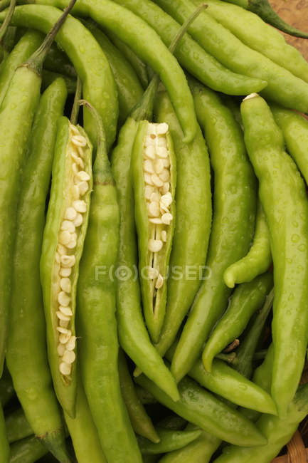 Frische grüne Chilischoten oder Paprika, eine Gemüsewürze, scharf im Geschmack mit zwei gespaltenen geöffneten Stücken, die das Innere weißer Samen zeigen. — Stockfoto