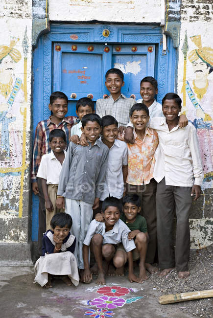 Indian children in front of closed blue door. Salunkwadi, Ambajogai, Beed, Maharashtra, India — Stock Photo