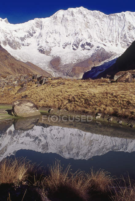 Vista de picos de montanhas e pequena lagoa com reflexão durante o dia — Fotografia de Stock