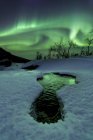 Polarlichter über gefrorenem Fluss — Stockfoto