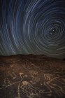Trilhas estelares sobre o antigo sítio petroglifo — Fotografia de Stock