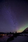 Aurora boreal y Vía Láctea sobre Carcross - foto de stock