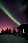 Aurora borealis above cabin — Stock Photo