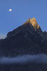 Monduntergang und Alpenglühen über schneebedecktem Gipfel — Stockfoto