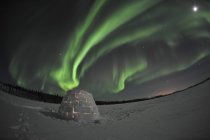 Aurora boreal sobre iglú en el lago Walsh - foto de stock