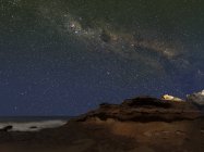 Млечный Путь показывает фигуру, известную как Эму, поднимающуюся над скалами в Мирамаре, Аргентина — стоковое фото