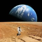 Astronaut looking up at alien sun and standing on barren planet — Stock Photo