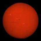Sole H-alfa di colore rosso con aree attive e filamenti su sfondo nero — Foto stock