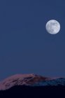 Pleine lune au-dessus des montagnes à Alpenglow, New Aiyansh, Colombie-Britannique, Canada — Photo de stock