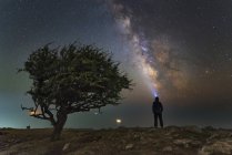 Uomo in piedi sulla costa del Mar Nero con Via Lattea in cima alla montagna Ilyas-Kaya, Crimea — Foto stock