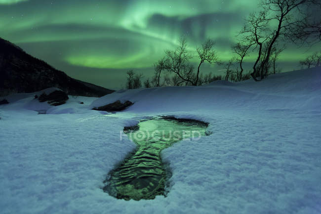 Aurora Boreal sobre el río congelado - foto de stock