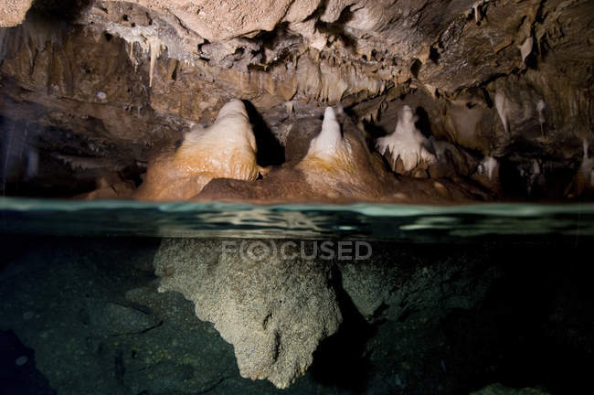 Сталактиты и сталагмиты в подводной пещере — стоковое фото