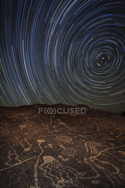 Star trails over ancient petroglyph site — Stock Photo