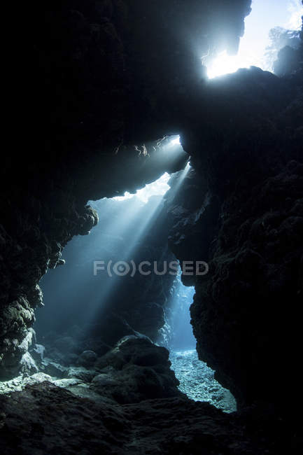 Lumière du soleil éclaircissant crevasse dans le récif — Photo de stock