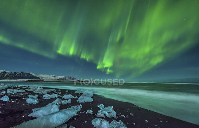 Aurora borealis over ice beach — Stock Photo