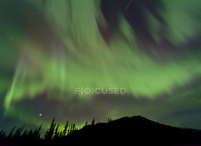 Aurora boreal sobre la montaña - foto de stock