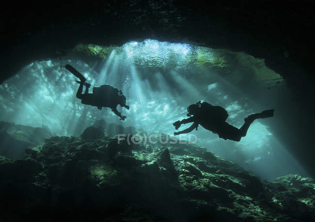 Divers in entrance to Chac Mool cenote — Stock Photo