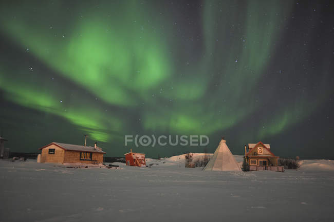 Aurora boreal por encima de la aldea - foto de stock