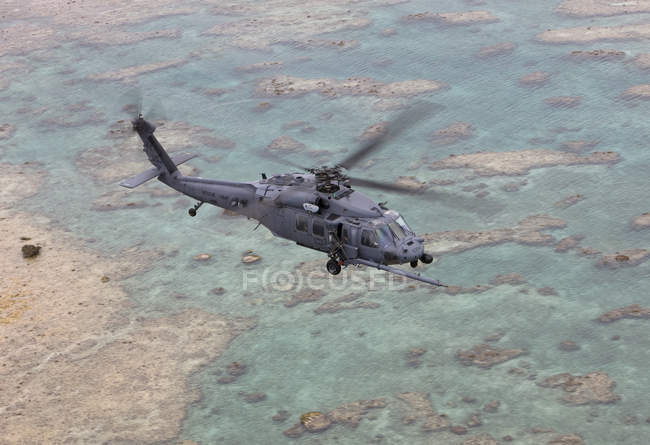 Japón, Okinawa - 24 de junio de 2009: HH-60G del 33º Escuadrón de Rescate volando a lo largo de la costa de Okinawa durante la misión de entrenamiento fuera de la Base Aérea de Kadena - foto de stock
