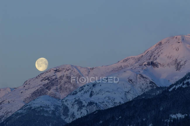Moonset y Alpenglow, New Aiyansh, Columbia Británica, Canadá - foto de stock