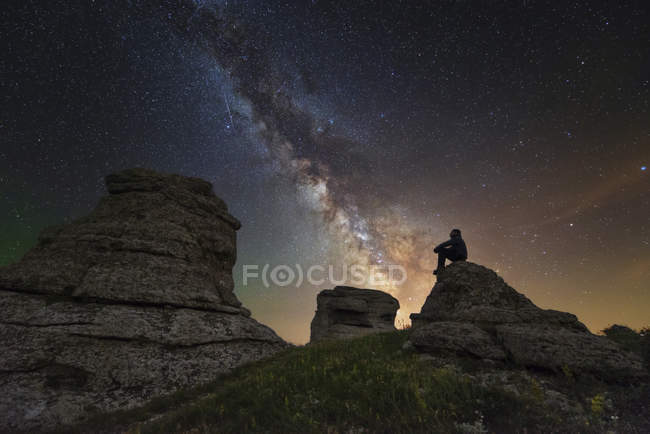 Man sitting on top of Demerdzhi mountain under Milky Way at night in Alushta, Crimea — Stock Photo