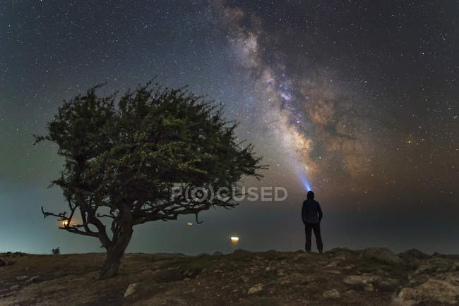 Uomo in piedi sulla costa del Mar Nero con Via Lattea in cima alla montagna Ilyas-Kaya, Crimea — Foto stock