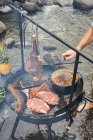 Hombre chef cocinar carne barbacoa en el incendio forestal - foto de stock