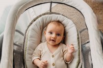 Young baby laying in bassinet and looking up at camera and smiling — Stock Photo