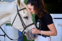 Mädchen kümmert sich um ihr Pferd vor dem Reitunterricht — Stockfoto