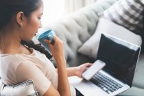Mulher trabalhando em laptop e beber café — Fotografia de Stock