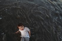 Hochwinkelblick auf glückliches Kleinkind Mädchen, das im Ozean spielt — Stockfoto