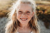 Retrato de menina em idade escolar com sardas sorrindo para a câmera — Fotografia de Stock