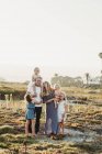 Stile di vita ritratto di famiglia con giovani ragazze sorridenti al tramonto sulla spiaggia — Foto stock