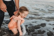 Дівчина Тоддлер бризкає в океані з батьком на заході сонця — стокове фото