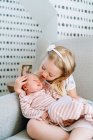 Portrait of beautiful little girl with her baby brother at home — Stock Photo