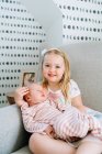 Portrait of beautiful little girl with her baby brother at home — Stock Photo