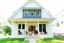 New family relaxing  together on a modern farmhouse porch — Stock Photo
