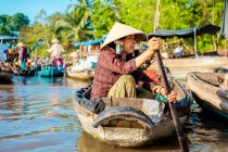 Вьетнамская женщина ловит лодку на плавучем рынке Фонгдьен, район Фонгдьен, Кантхо, дельта Меконг, Вьетнам — стоковое фото