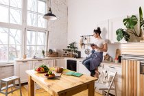 Junge und schöne Hausfrau kocht in einer Küche — Stockfoto