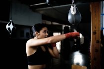 Jeune femme pratiquant la boxe au gymnase — Photo de stock