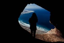 Silhouette eines Mannes aus einer Höhle in den Klippen von Famara auf Lanzarote — Stockfoto