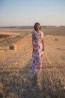 Femme observant le champ sec au coucher du soleil — Photo de stock
