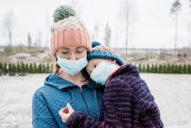 Mother carrying son with face masks on for protection from virus & flu — Stock Photo